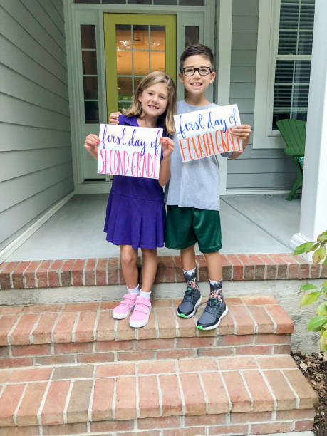 First Day of School Second grade girl and fourth grade boy looking happy on their first day of school. first day of school stock pictures, royalty-free photos & images