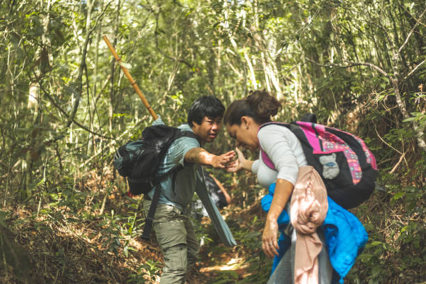 istock Man helps woman climb the trail 1250045171