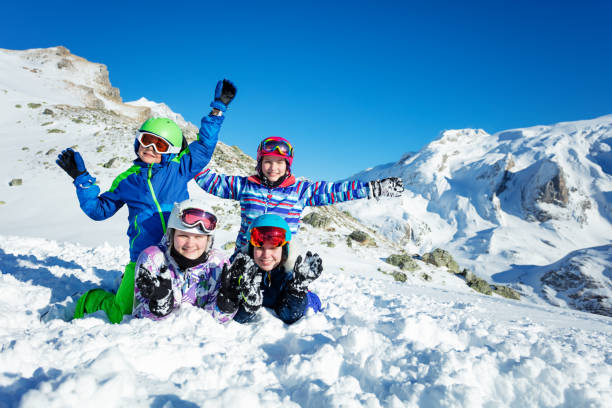 istock Children lay in snow and wave hands over mountains 1250045371