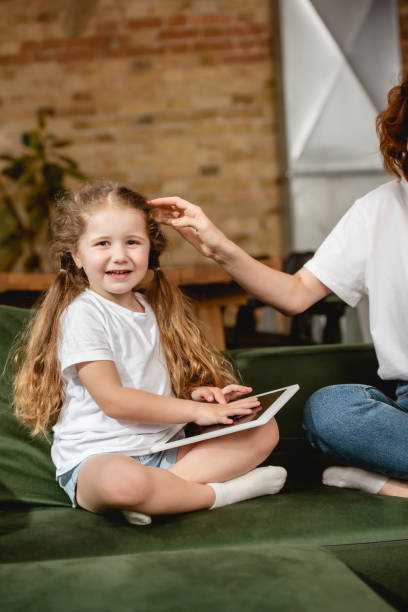 istock mother touching cute daughter with digital tablet 1250046620