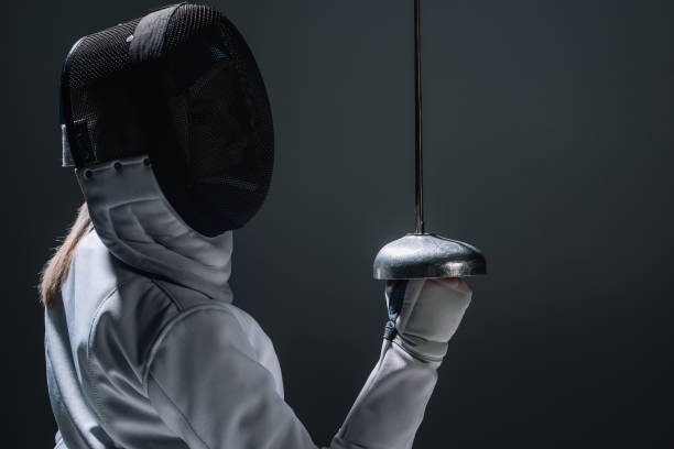 istock Back view of fencer holding rapier isolated on black 1250046748