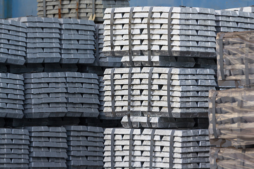 Stack of raw aluminium ingots in factory stock yard.