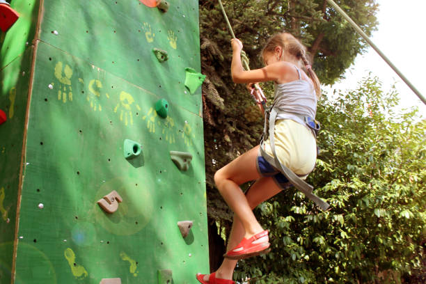 istock girl comes down from the climbing wall on a rope 1250047944