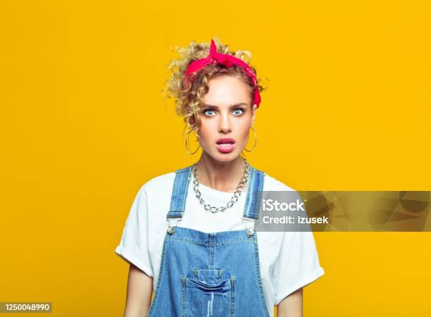 Shocked Young Woman In 80s Style Outfit Portrait On Yellow Background Stock Photo - Download Image Now