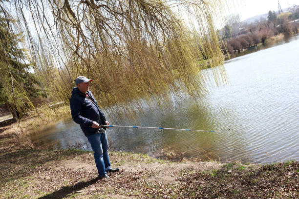istock Elderly man fishing on lake in spring 1250054100