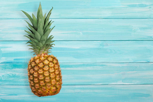 istock Ripe pineapple on a blue wooden background. 1250057280