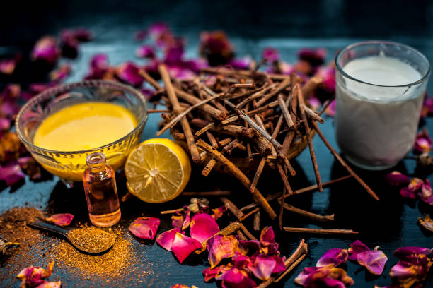 Face mask of manjistha or Indin madder root on a black wooden surface consisting of manjistha roots powder, lemon, milk and some essential rose oil. Face mask used for minor skin infections and acne. máscara facial de manjistha o raíz de madder indin en una superficie de madera negra que consiste en polvo de raíces de manjistha, limón, leche y algún aceite de rosa esencial. máscara facial utilizada para infecciones menores de la piel y acné.