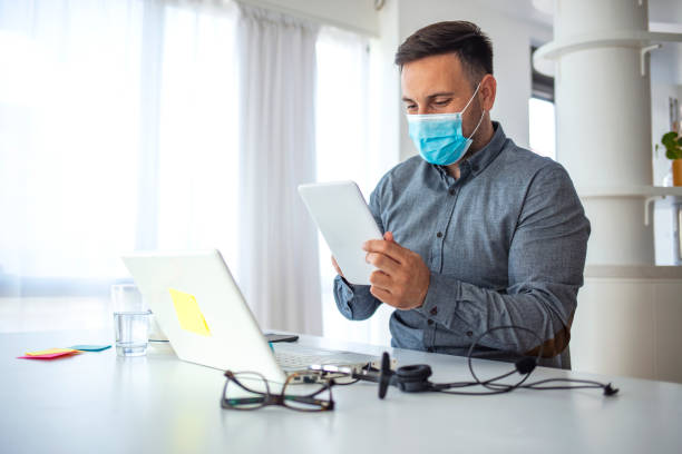 istock Man in a medical mask at the office. 1250063736