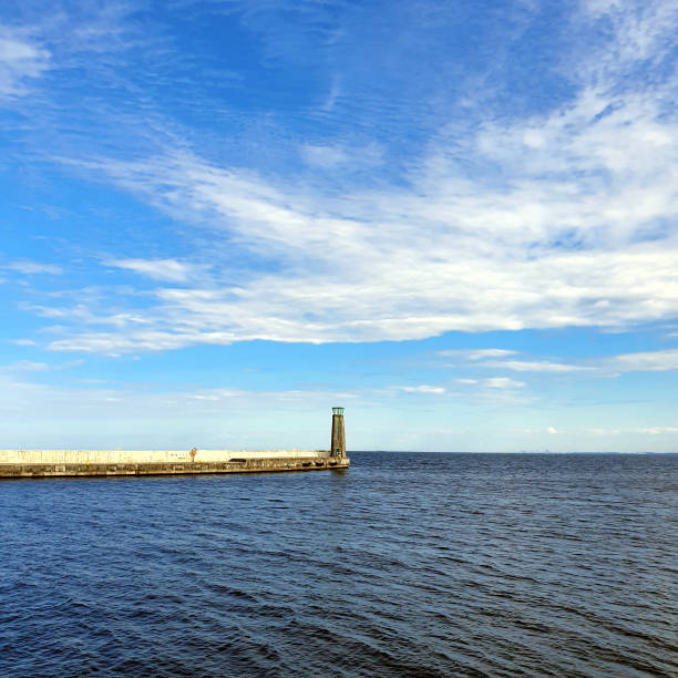 istock Lighthouse on a calm sea. White clouds in the sky. 1250064186