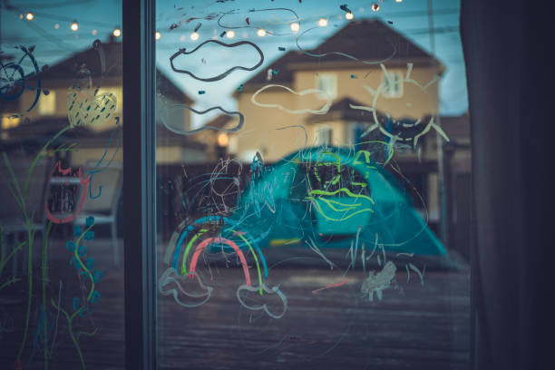 Drawings on a patio door during covid-19 lockdown. View from inside the house. There is also a rainbow drawn on the glass meaning everything will be fine.