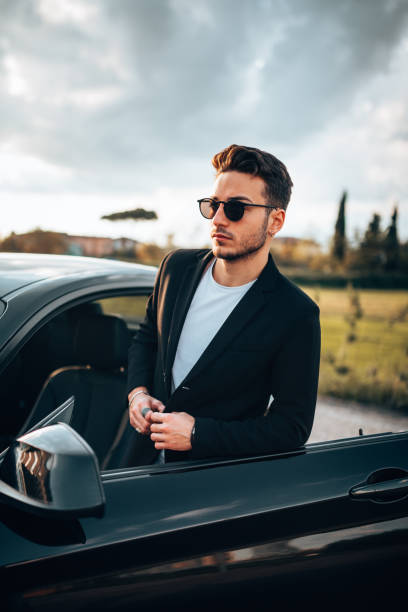 istock serious fashion man with a car 1250064586