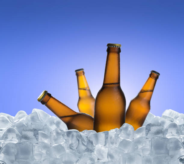 istock Cold bottle of beer with drops in ice cubes over blue background 1250065342