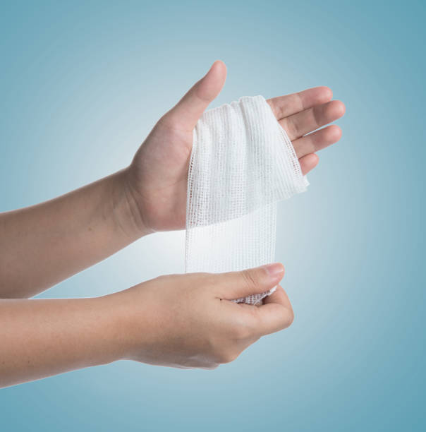 istock Injured hand with bandage on blue background 1250065400