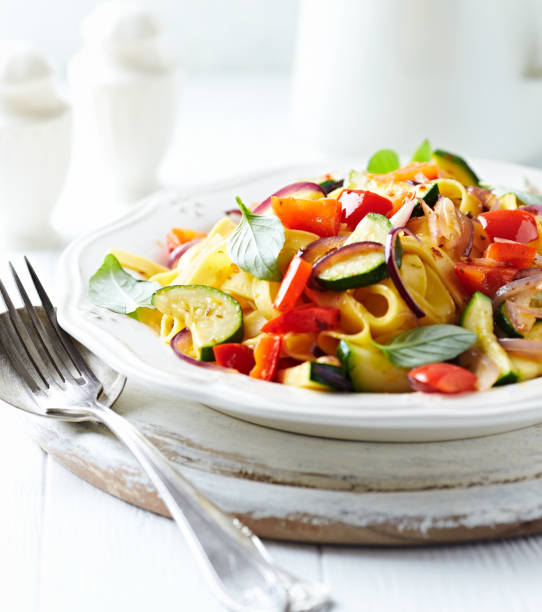 istock Pappardelle Pasta with Vegetables and fresh Basil on bright wooden Background. 1250065421