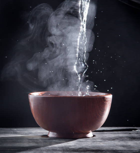 istock Pouring hot water into into a bowl on a black background 1250065666
