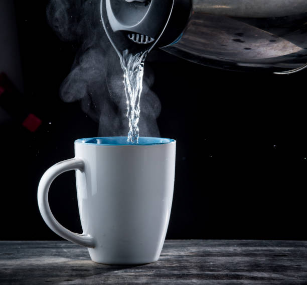 istock Pouring hot water into into a cup on a black background 1250065669
