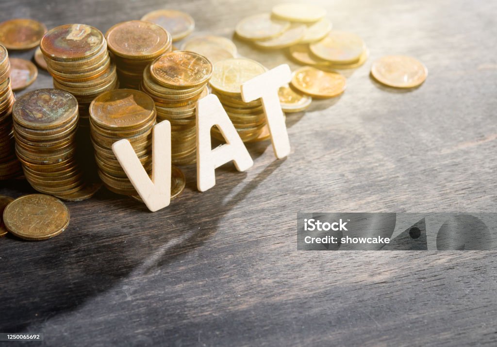 Mehrwertsteuer Holz Wort mit gestapelten Münzen auf dunklem Holzhintergrund - Lizenzfrei Mehrwertsteuer Stock-Foto