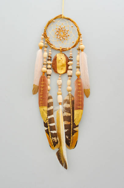 istock Native dream catcher with painted golden feathers on gray background 1250066019