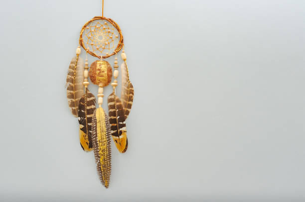 istock Native dream catcher with painted golden feathers on gray background 1250066023