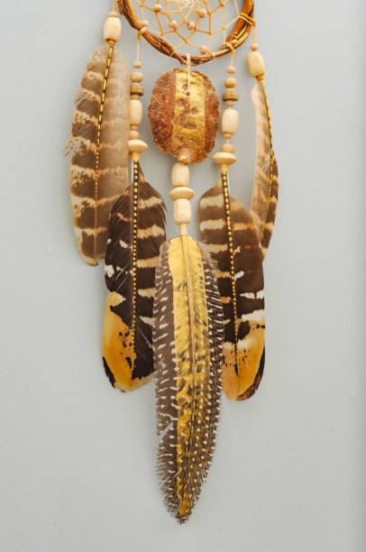 istock Native dream catcher with painted golden feathers on gray background 1250066216