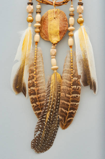 istock Native dream catcher with painted golden feathers on gray background 1250066614