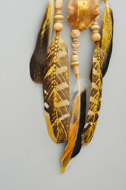 istock Native dream catcher with painted golden feathers on gray background 1250066669