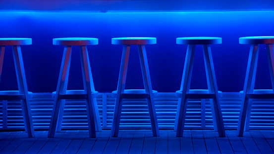 A bar with stools at night