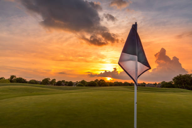 sonnenuntergangshimmel über dem fairway eines golfplatzes in texas - golf golf flag sunset flag stock-fotos und bilder