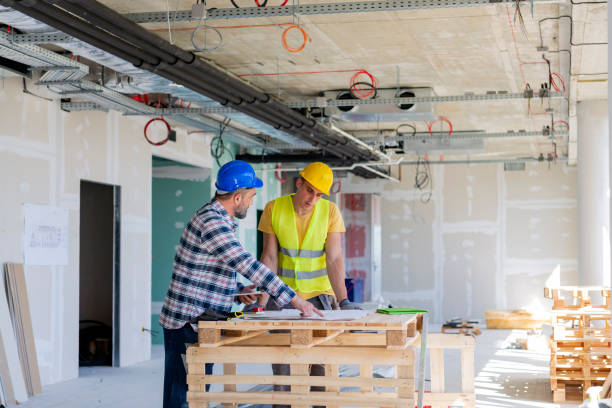 istock Male engeneers workers foreman at a indoors building site with blueprints 1250072777