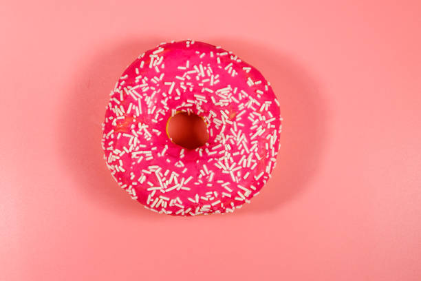 istock Tasty pink donut on pink background 1250072914