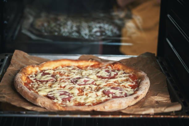 Little Girls Baking Pizza in the Oven