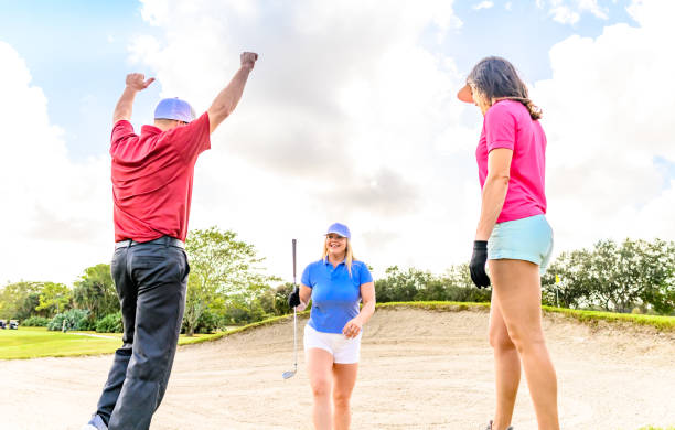 trio joue au golf sur un beau vert scénique, homme et deux femmes sportives - golf golf swing putting cheerful photos et images de collection