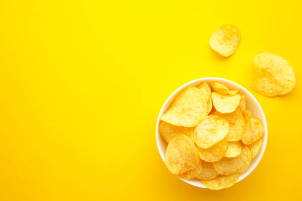 istock Potato chips on bowl on yellow background 1250086678