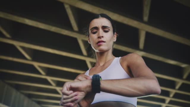 women jogging looking at smartwatch