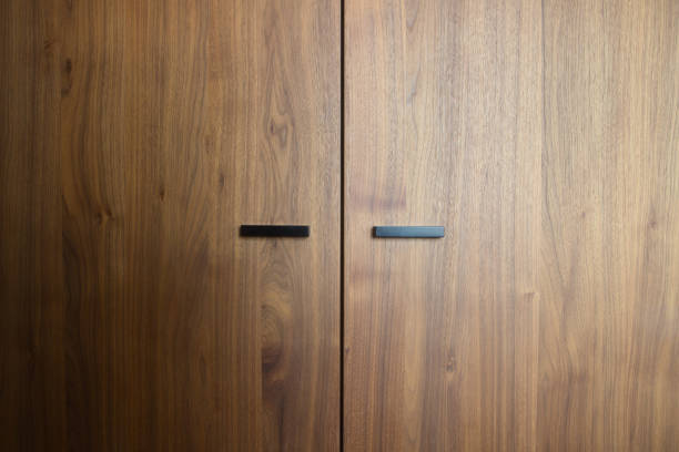 Beautiful brown wooden oak doors of a cabinet with black modern handles modern background texture Beautiful brown wooden oak doors of a cabinet with black modern handles modern background texture close-up oak wood material stock pictures, royalty-free photos & images