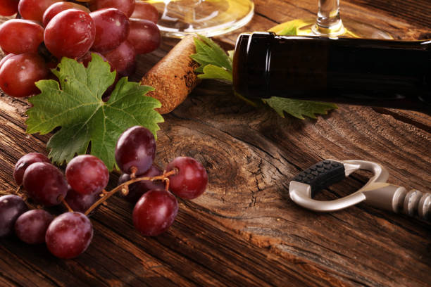 red Wine with red grapes and bottle on rustic background