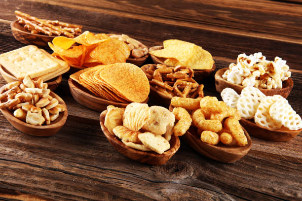 istock Salty snacks. Pretzels, chips, crackers in wooden bowls on table 1250095362