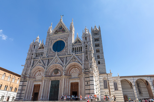 Siena, Italy - June 28, 2018: Panoramic view of exterior of Siena Cathedral (Duomo di Siena) is a medieval church in Siena, dedicated from its earliest days as a Roman Catholic Marian church