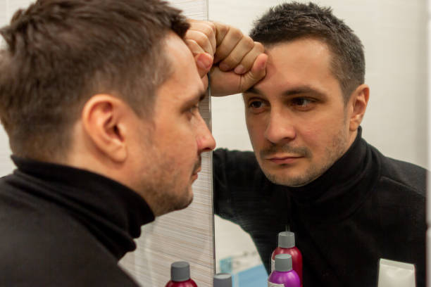 istock reflection of a young guy looking in a mirror. 1250096228