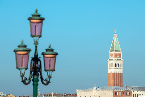 Lamppost detail and view of the St Mark's Campanile, Venice, Italy. Focus on Campanile.