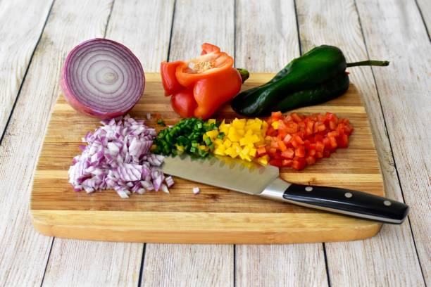 Wooden cutting board with fresh organic vegetables for chopping and dicing to make delicious homemade meals Clean peppers and onions chopped and diced for vegetarian soup or stir fry dinner chop stock pictures, royalty-free photos & images