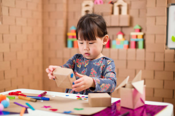 istock toddler girl  making craft by using cardboard for homeschooling 1250100154