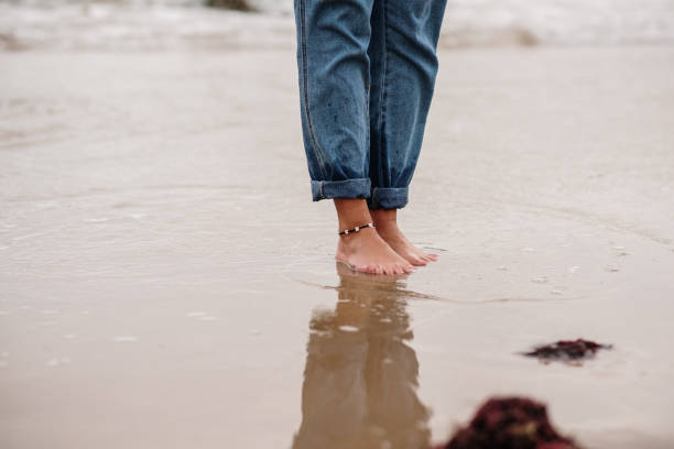 istock Two feet standing by the sea at beach 1250103637