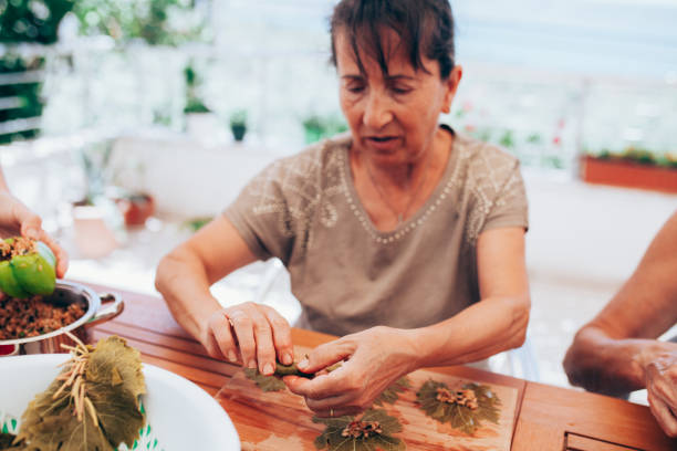 istock Women preparing grape leaves with rice 1250108703