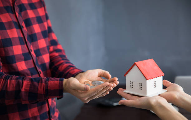 istock woman hand house model with man hand coins 1250110112