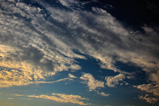 istock flakes of white clouds, forming a strip that floats under the twilight sky. 1250110919