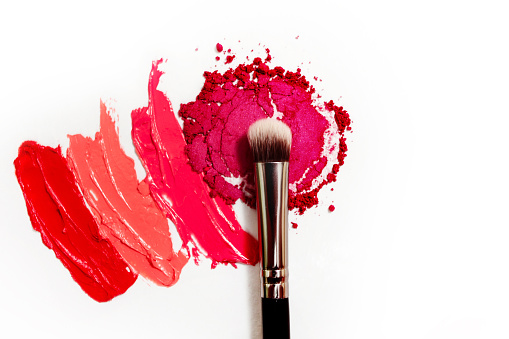Lipstick and lip gloss, drops and strokes of different shades to create different images in makeup, white background. Cosmetics and make-up, beauty concept