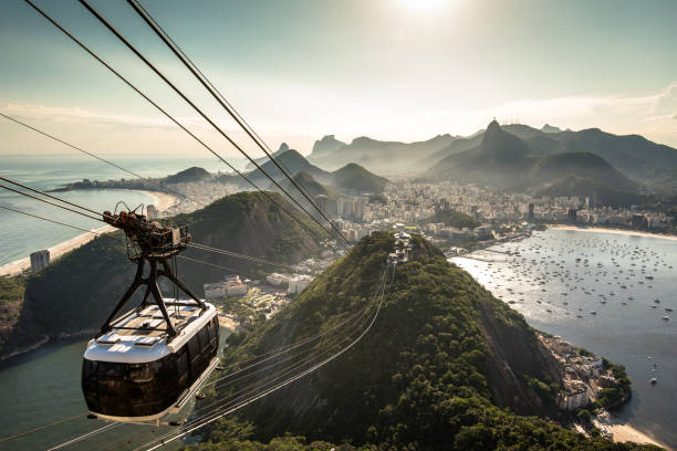 Cable Car Going Up to the Sugarloaf Mountain in Rio Rio de Janeiro, Brazil - November 10, 2016: View of Rio de Janeiro city from the Sugarloaf Mountain by sunset with a cable car approaching. corcovado stock pictures, royalty-free photos & images