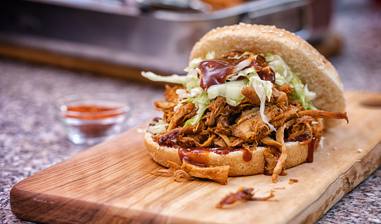 Freshly prepared pulled pork sandwich with coleslaw and barbecue sauce