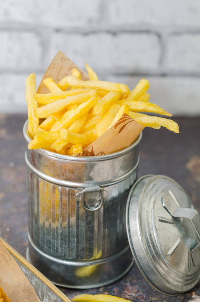 istock French fries in metallic basket isolated on rustic background 1250119541